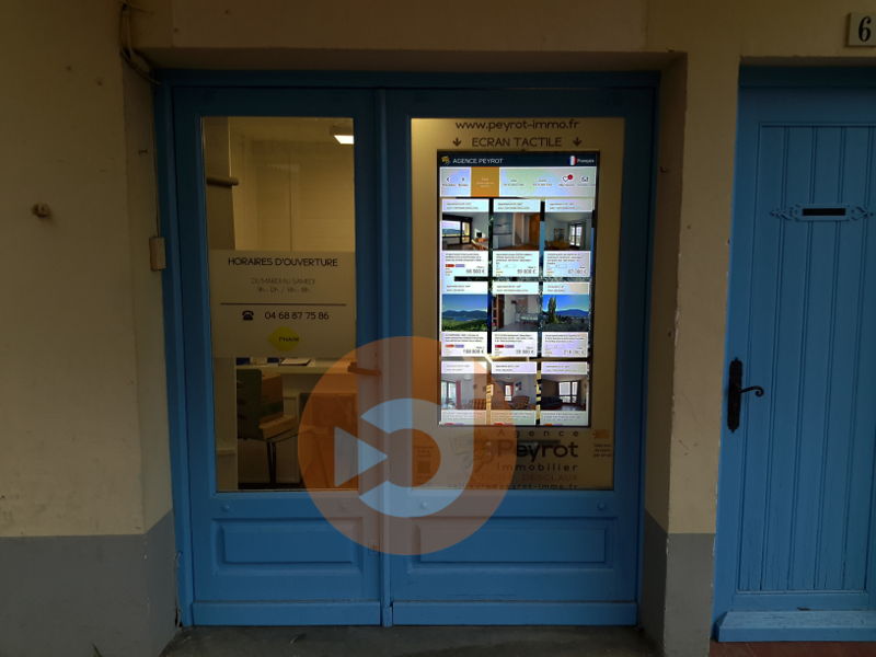 Image écran vitrine tactile installée dans une agence immobilière du groupe PEYROT IMMOBILIER